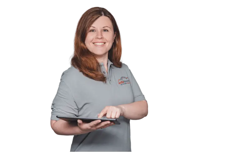 Eine IT-Technikerin für DMS-Systeme hält ein Tablet in der Hand und bedient es mit einem Finger. Dabei lächelt Sie freundlich in die Kamera.